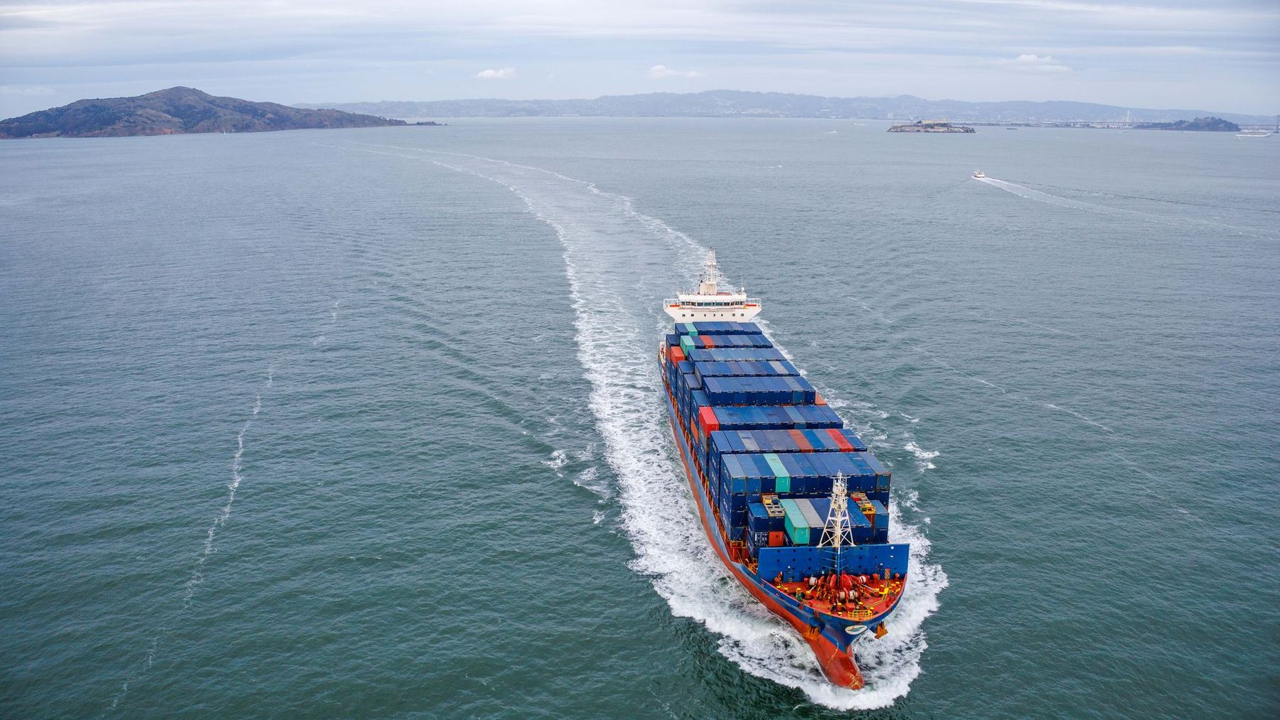 Container vessel under way in open water, seen from astern